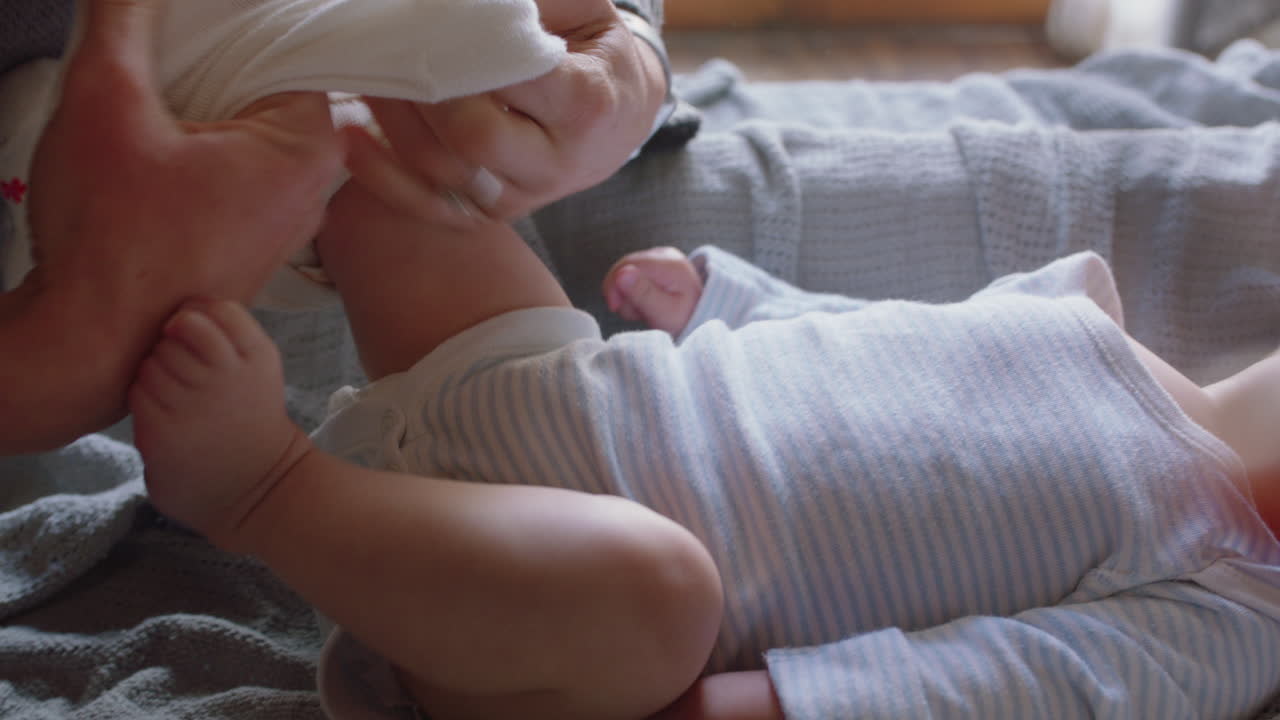 아기와 함께 행복한 어머니 아름다운 유아를 입히고 유아를 돌보는 부드러운 엄마 가정에서 아이를 키우는 어머니를 즐기고