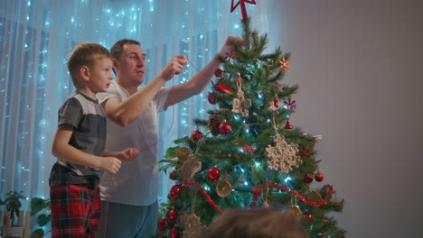 Padre-Y-Dos-Hijos-Decoran-Juntos-El-árbol-De-Navidad.-Imágenes-4k-De-Alta-Calidad