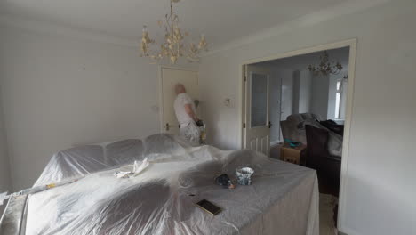 a professional painter and decorator carefully painting a room, using protective coverings and precise techniques to ensure a clean finish.