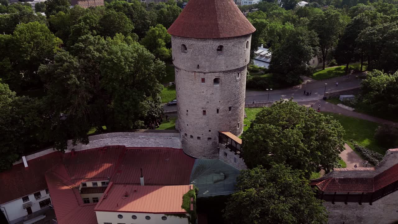 Drone footage captures the medieval walls surrounding Tallinn Old Town with ancient towers rising above red rooftops showcasing centuries of rich history and architectural heritage