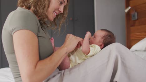 Video-of-happy-caucasian-mother-playing-with-newborn-baby