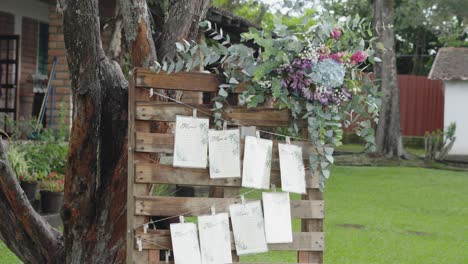 a wooden sign with a bouquet of flowers and cards