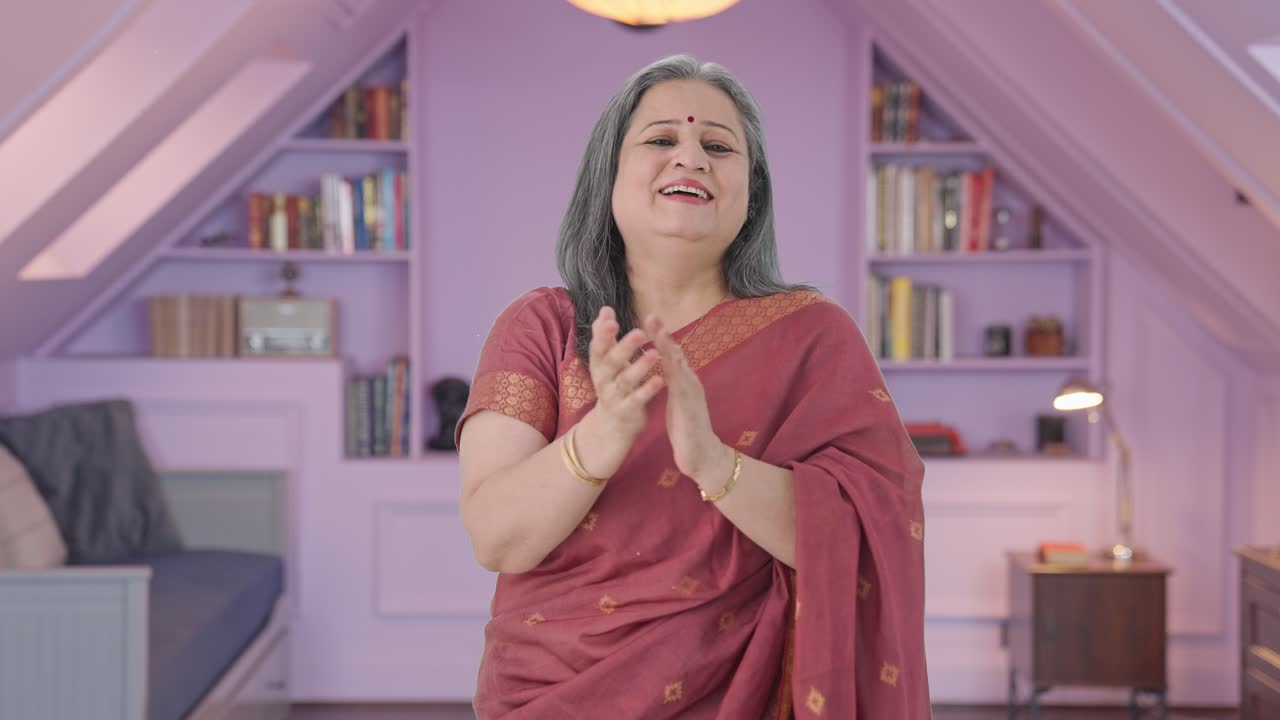 Wanita tua India yang bahagia bertepuk tangan dan mengapresiasi.
