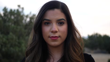 mujer hispana adulta independiente que mira fuerte y seria a la cámara con confianza, optimismo, positividad y determinación para el futuro de la humanidad