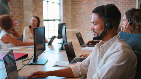 equipo de negocios multicultural con auriculares trabajando en el centro de atención al cliente