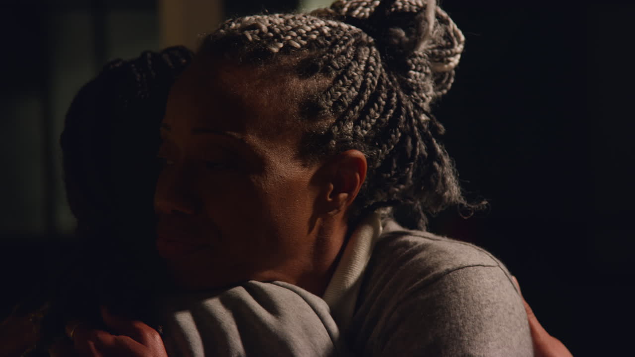 madre e hija abrazándose por la noche