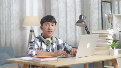 집에서 노트북으로 공부하는 십대 소년