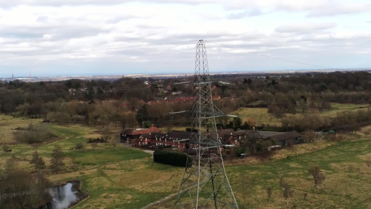 volando alrededor de un pilón de distribución de electricidad con vistas a la campiña británica