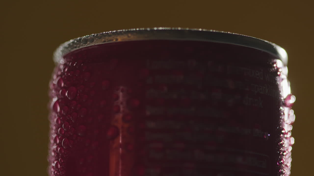 차가운 맥주 또는 탄산음료의 회전하는 테이크아웨이 캔에 응축 방울의 가까운 백라이트  1