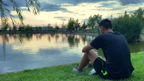 young man finds tranquility by the city lake in bucharest, romania