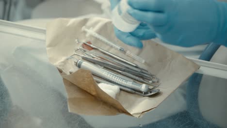 el dentista toma los instrumentos de la mesa.