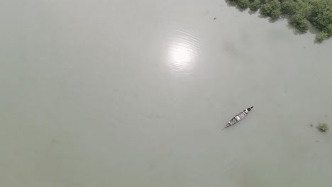 Hermosa-Toma-Aérea-De-Un-Pescador-Indio-En-Un-Bote-De-Canoa-De-Madera