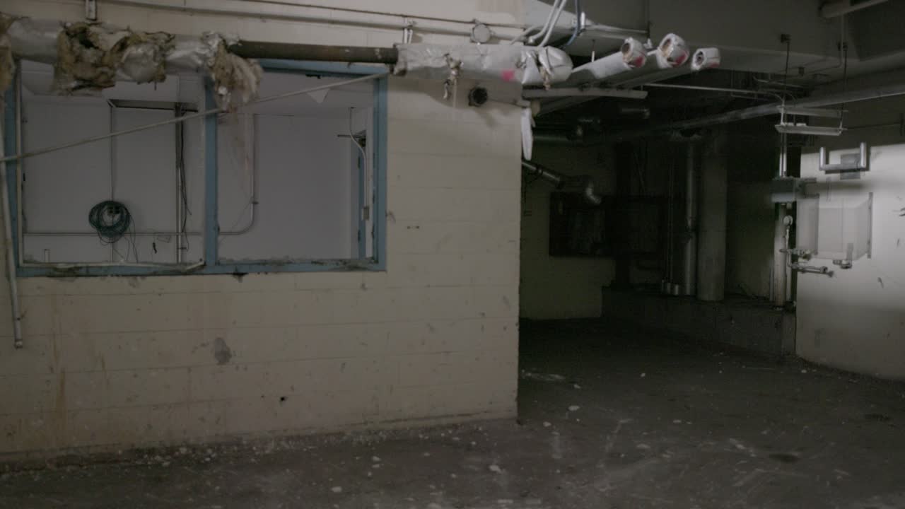 A fast tilt shot from the ground to looking up a round shaft of an abandoned factory.