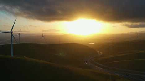 Dramatic-sunset-above-rotating-wind-generators-in-California,-USA---Aerial-view