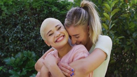 Portrait-of-happy-diverse-female-couple-embracing-and-smiling-in-garden