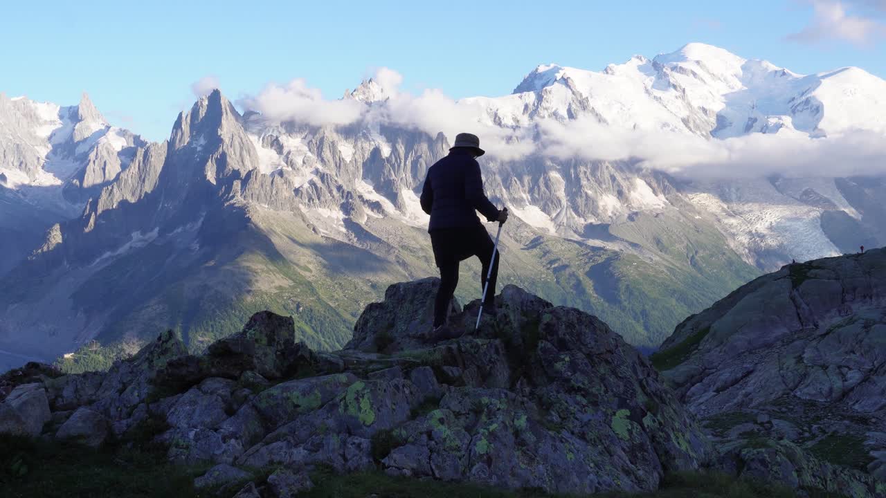 una mujer está haciendo senderismo en los alpes franceses con vistas al mont blanc y a la increíble cordillera de francia, durante las horas del atardecer, cerca de lac blanc