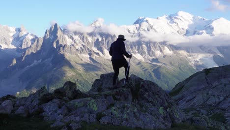 A-woman-are-hiking-in-the-French-Alps-overlooking-Mont-Blanc-and-the-amazing-mountain-range-of-France,-during-the-sunset-hours,-close-to-Lac-Blanc