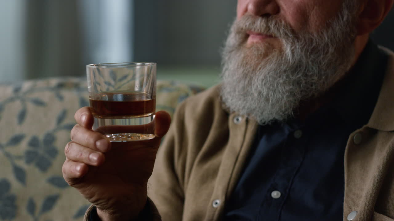 거실 에서 알코올 음료 를 마시는 노인