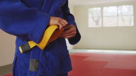 Judoka-putting-on-the-yellow-belt