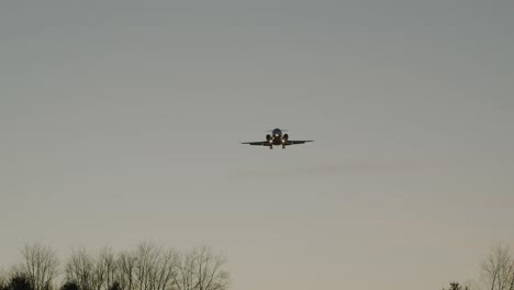 un jet privado hace un sobrevuelo bajo al atardecer