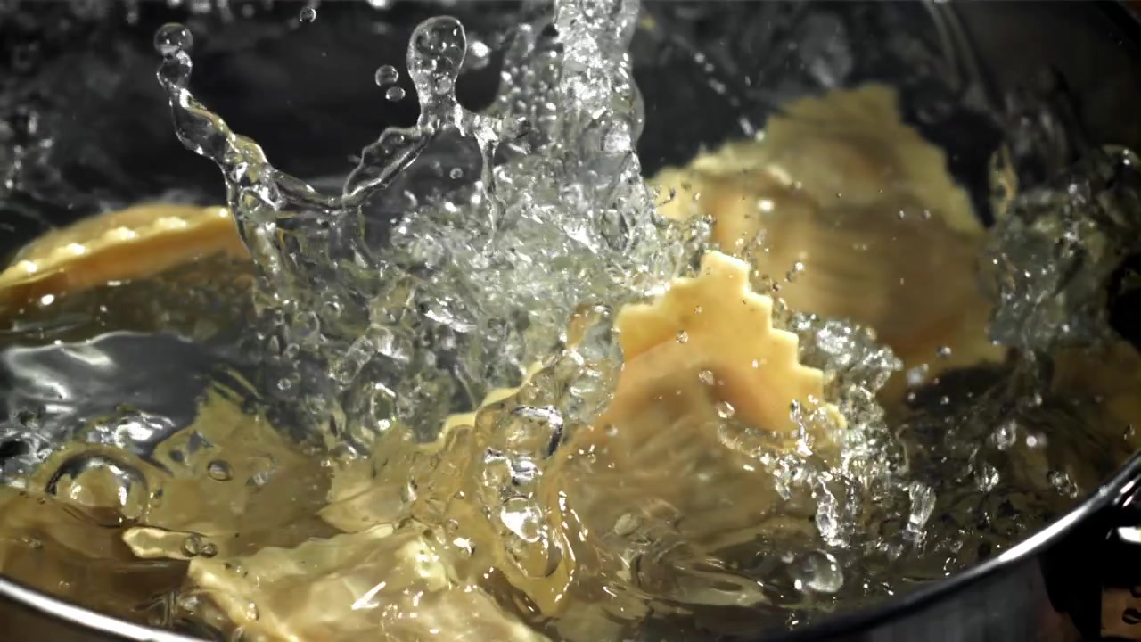 Ravioli fallen in Zeitlupe in kochendes Wasser