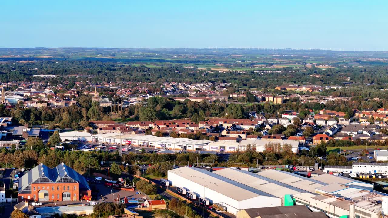 Vista aerea di una città industriale che mostra magazzini, fabbriche e case residenziali circondate da alberi e campagna