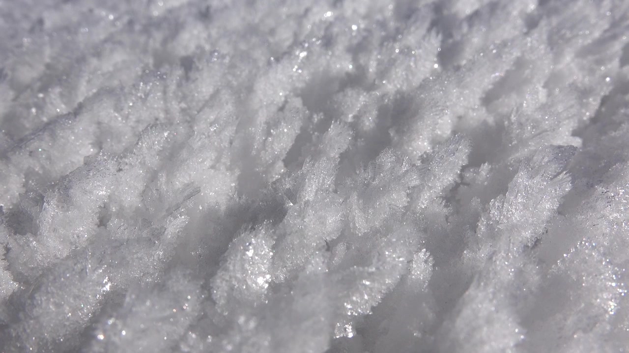 晴れた冬の日の結晶化した雪の質感のクローズアップ