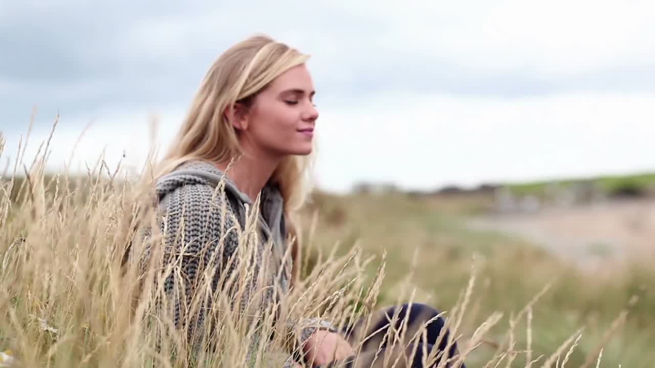блондинка отдыхает на дюнах в кинотеатре.