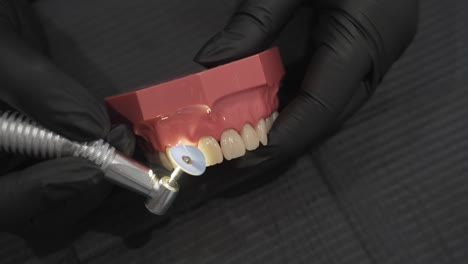 close-up of a dentist polishing a dental model