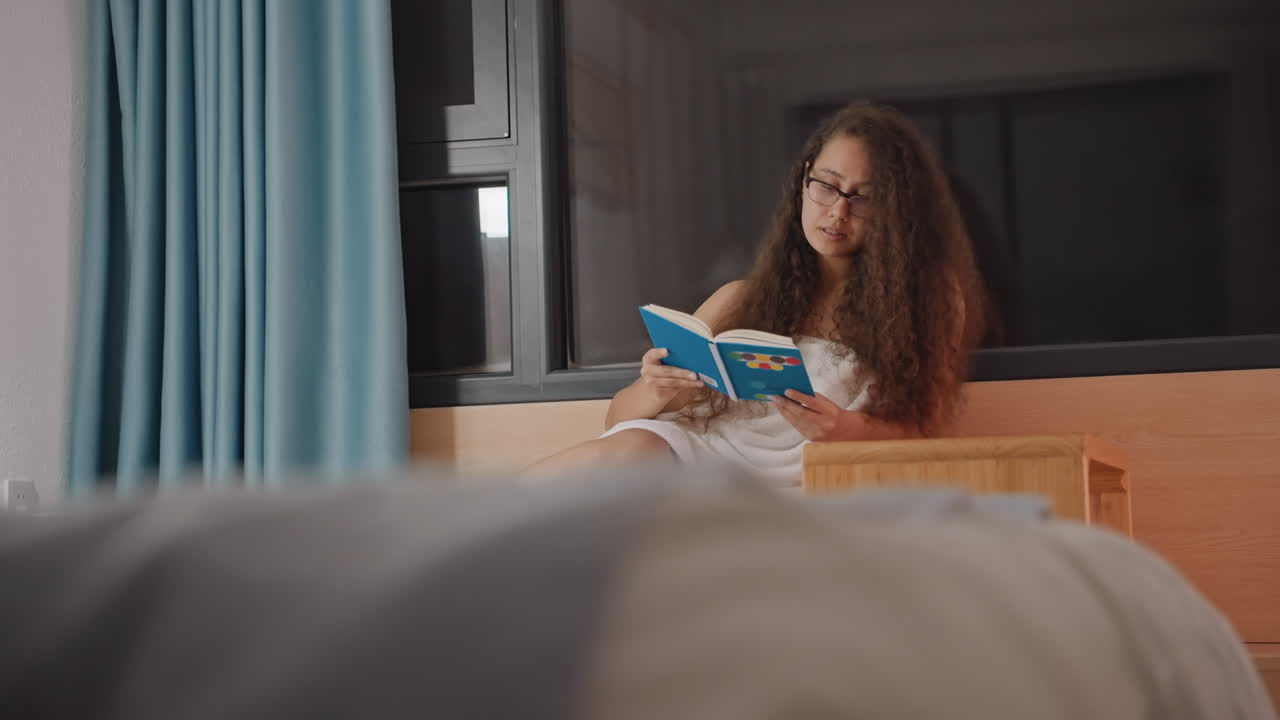 Donna tranquilla che si rilassa in un ambiente d'hotel pacifico. Scena pacifica di una donna che legge con calma in camera d'hotel. Una donna tranquilla si gode piacevolmente un'esperienza di lettura serena e silenziosa in hotel.