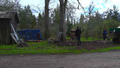 fast-motion footage of people raking leaves and loading them onto a tractor during spring day at a hageri countryside homestead, estonia. timelapse captures seasonal farm work and rural life teamwork