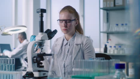 científico usando el microscopio en un laboratorio