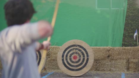 Toma-En-Cámara-Lenta-De-Una-Persona-Disparando-Una-Flecha-Con-Un-Arco-De-Madera-Medieval-En-Un-Objetivo-De-Práctica