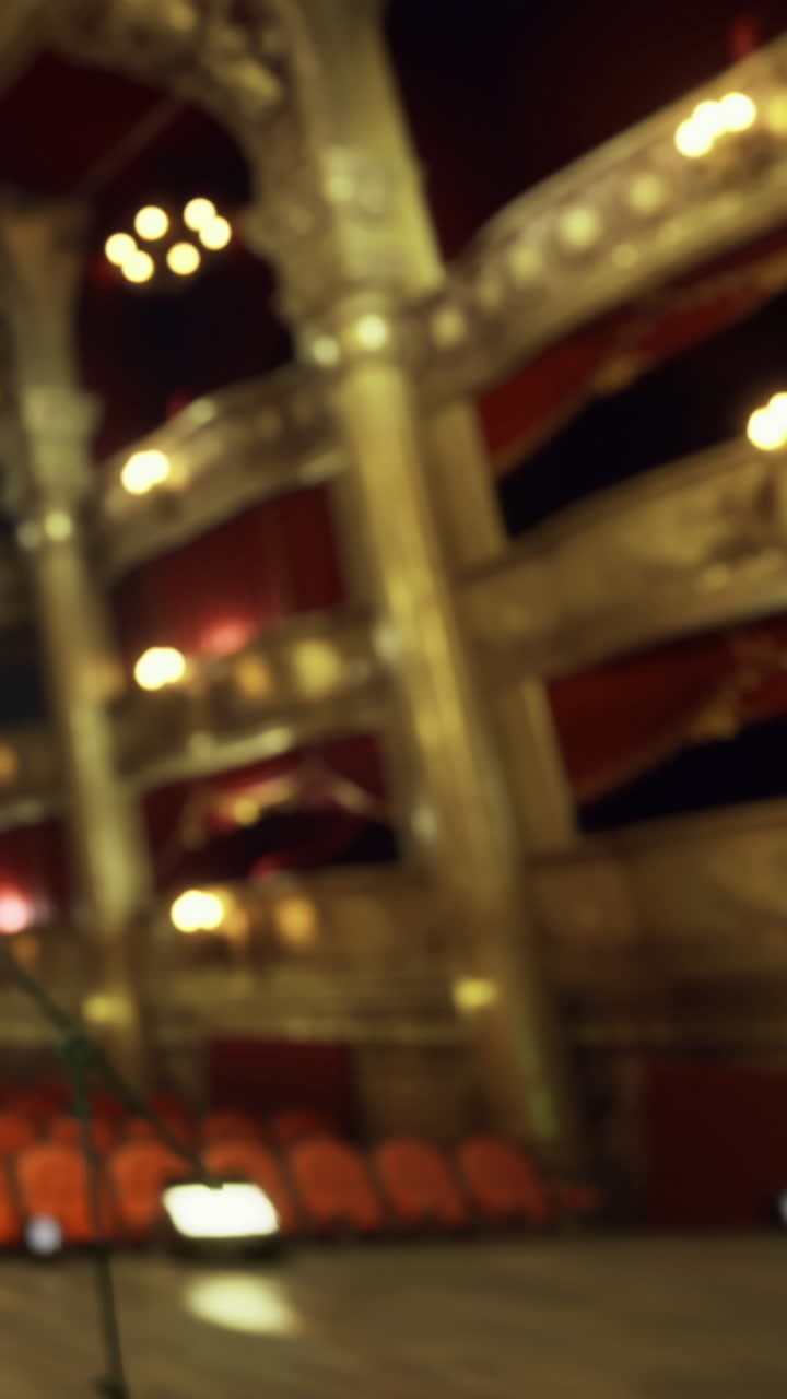 Allestimento scenico per uno spettacolo in un grande teatro con posti vuoti.