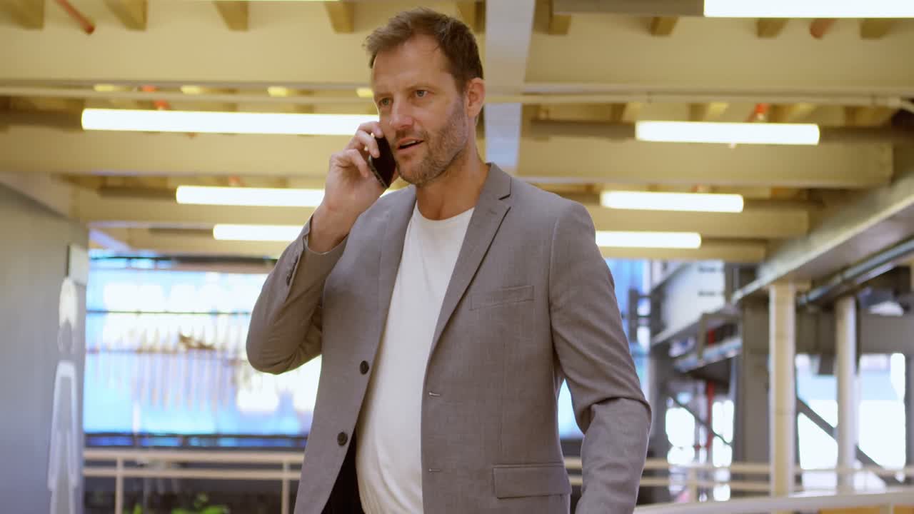 Forretningsmann snakker i mobiltelefon på kontoret 4k