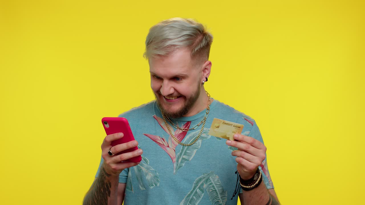 Man use mobile cell phone and plastic credit bank card, browsing say wow yes found out great big win