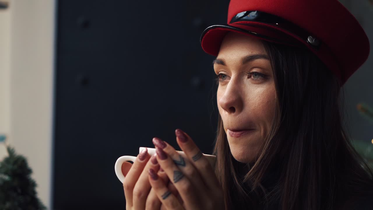 Donna con cappello rosso che beve caffè