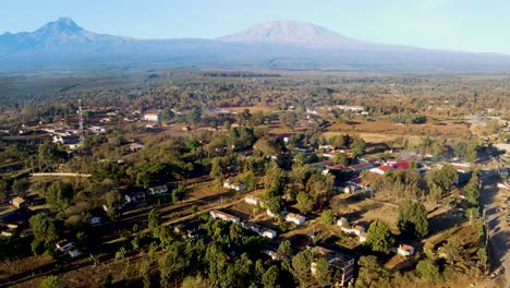 Sonnenaufgang-–-Kenia-Landschaft-Mit-Einem-Dorf,-Kilimandscharo-Und-Amboseli-Nationalpark-–-Verfolgung,-Drohnen-Luftaufnahme