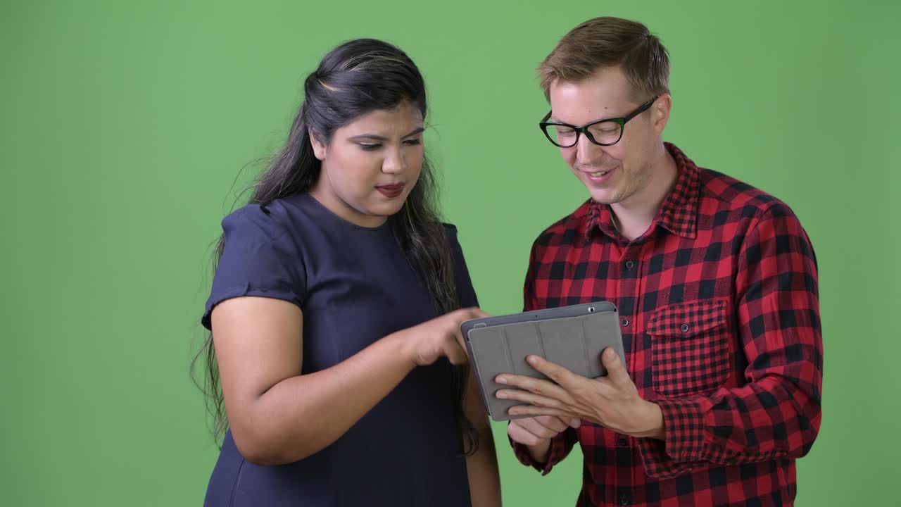 joven pareja de negocios multiétnica juntos contra un fondo verde