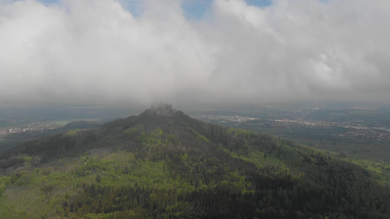vista aérea descendente de drones desde zellerhorn mirando hacia el castillo de hohenzollern bajo la niebla en el bosque negro, alemania
