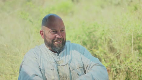 man in beekeeper suit smiling outdoors