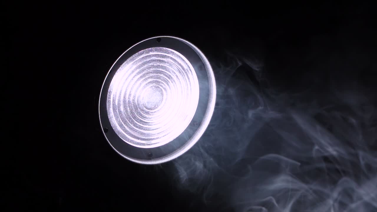 자동차의 헤드라이트 또는 무대 스포트라이트 빛은 어 속에서 빛나고, 신비롭고 불길한 연기가 천천히 떠다니며, 밤 촬영, 가까운.