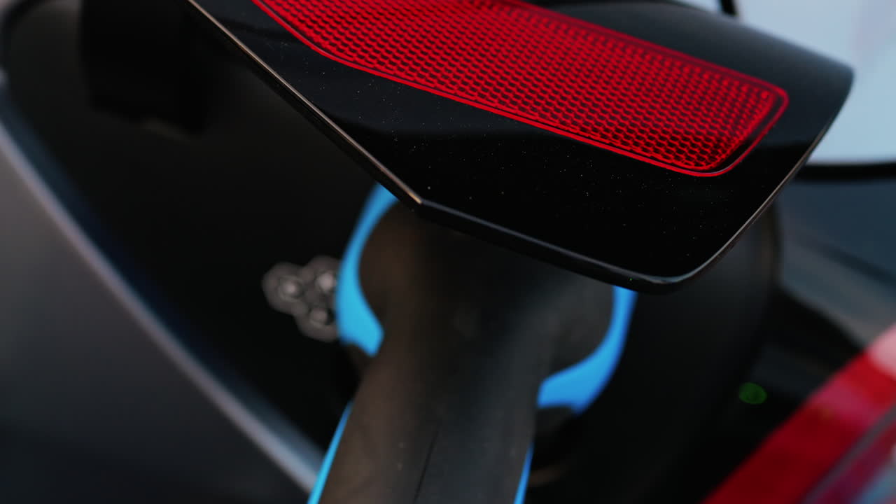 Close up of a blue electric car charger plugged into a car