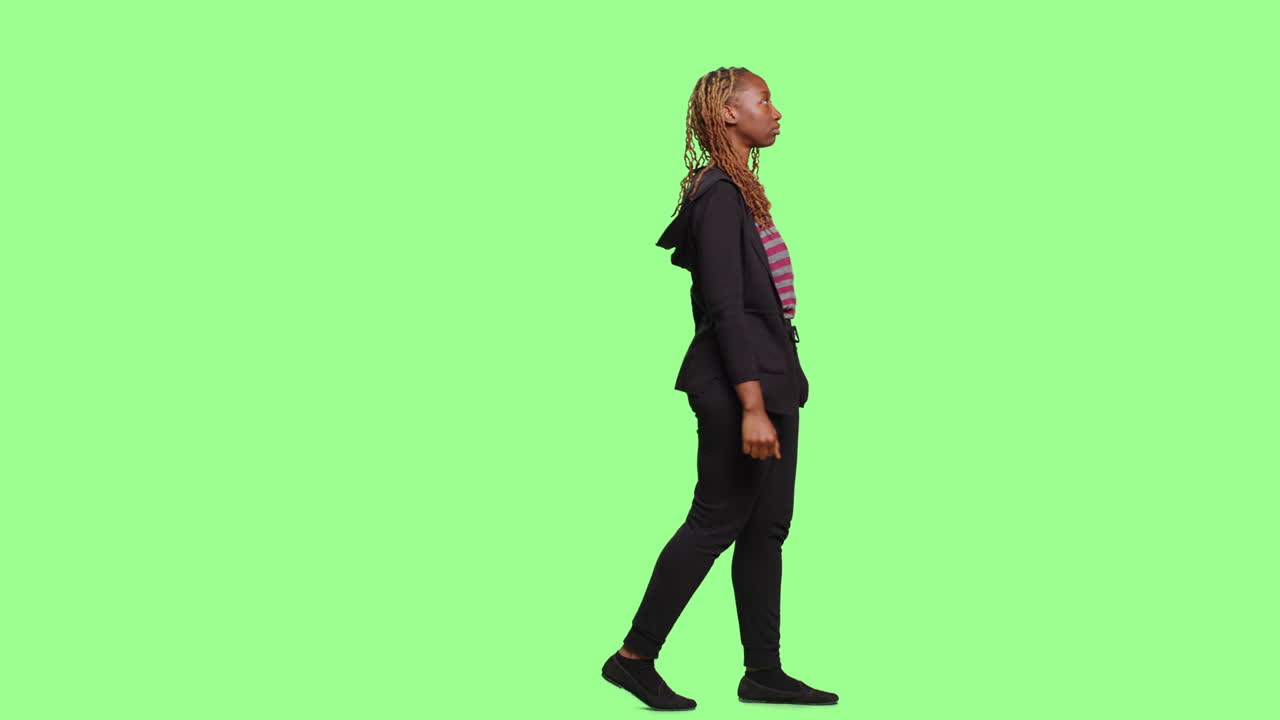 Woman walking against a green screen