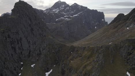 aerial view of rocky mountain layers in lofotodden national park, cloudy lofoten, norway - tracking, drone shot