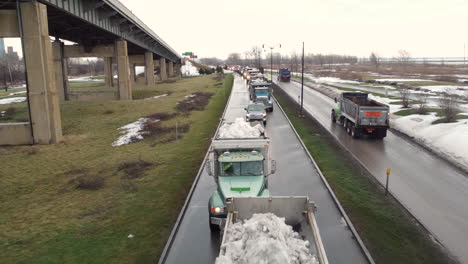 Reihe-Von-Muldenkippern,-Die-Nach-Der-Straßenräumung-Im-Winter-Mit-Schnee-Beladen-Sind