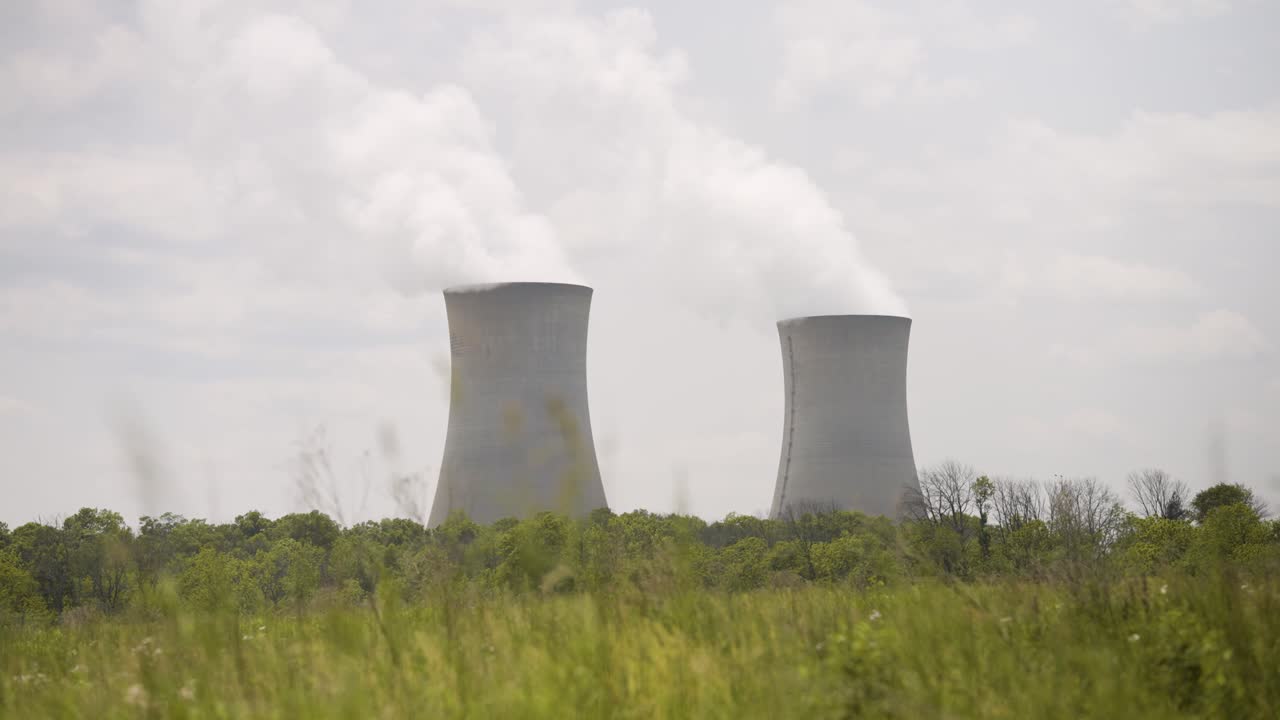 Nuclear Power Plant on a warm cloudy day with steam rising - handheld shot