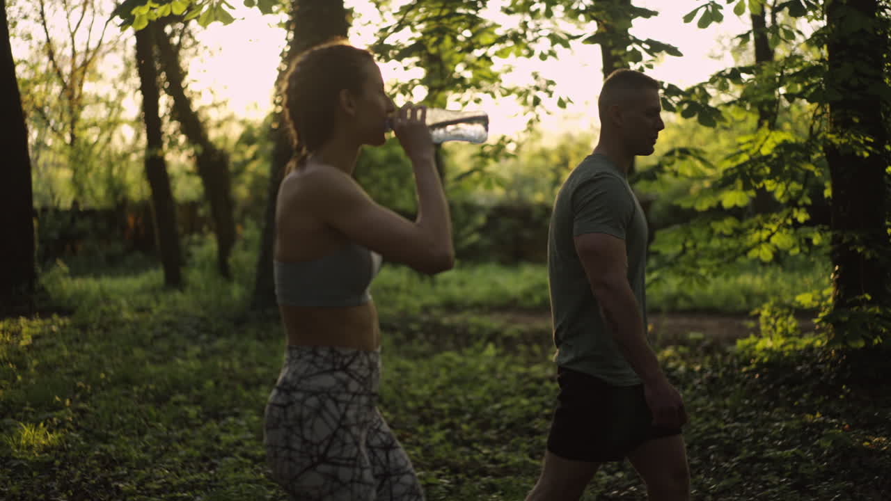 Couple exercising and hydrating outdoors