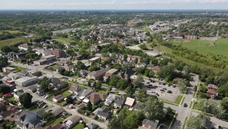 drone descends pushing in to chapel in middle of suburban neighborhood, sunny green day