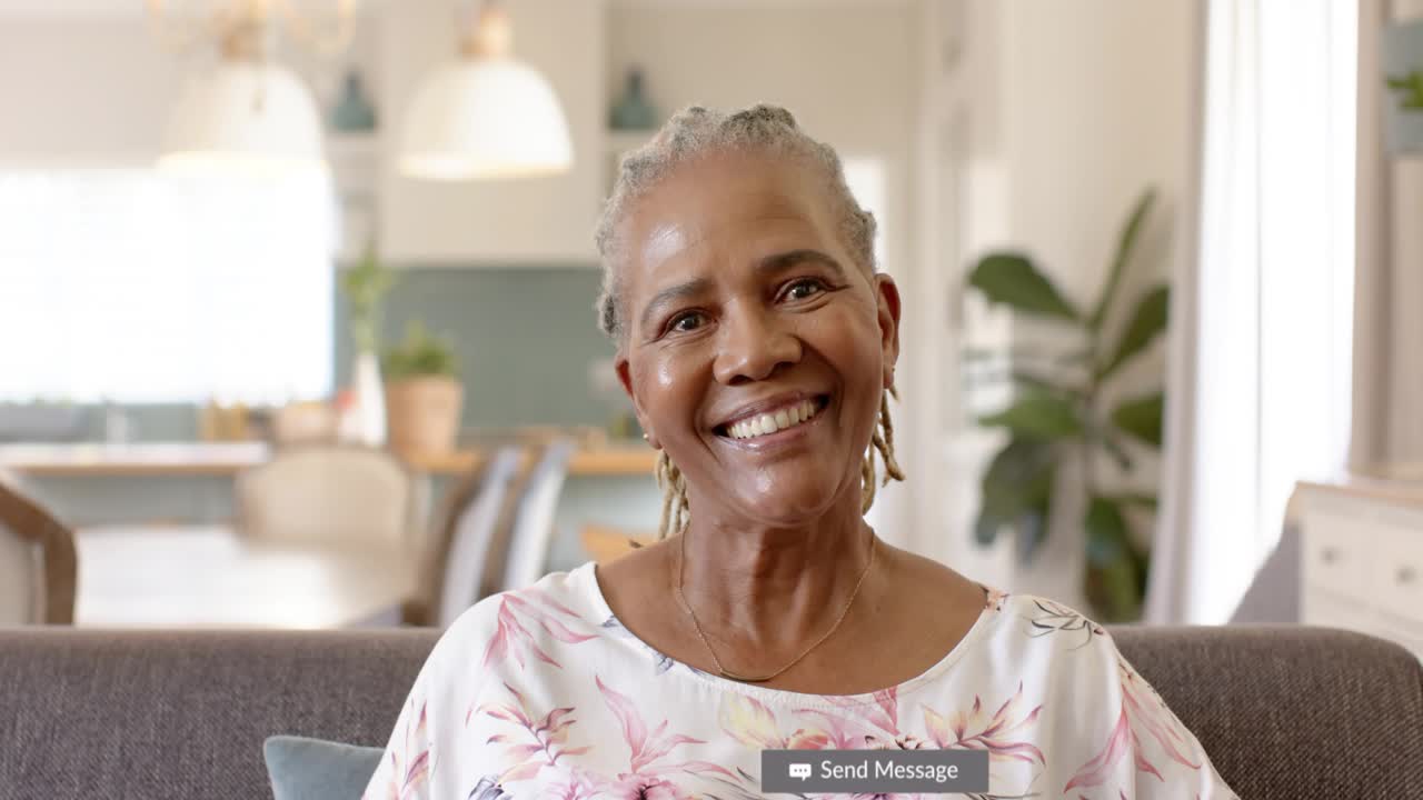 Senior woman sitting on sofa getting social badges covering face, drifting away, growing reach